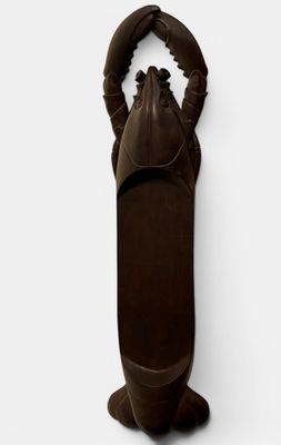 a brown lobster shaped object on a white wall