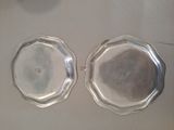 two silver trays sitting on top of a table next to each other