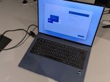 un ordinateur portable posé sur une table, avec une souris et un clavier