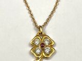 un collier en or avec un pendentif en forme de fleur sertie de diamants, monté sur une chaîne en or