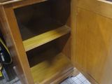 a wooden cabinet with a door open in a store