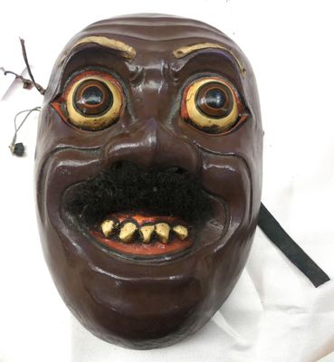 un masque marron avec un sourire sur le visage