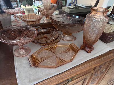 une table sur laquelle sont disposés de nombreux plats en verre et des vases