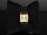 a close up of a watch with a bow tie on a table