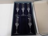 four empty wine glasses in a box on a table