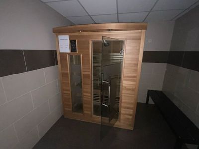 un sauna en bois avec une porte vitrée dans une salle de bains