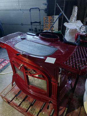 a red stove sitting on a pallet in a garage