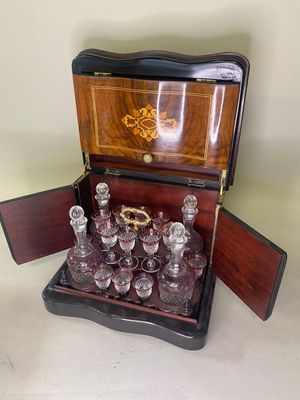 des bouteilles et des verres dans une caisse en bois posée sur une table