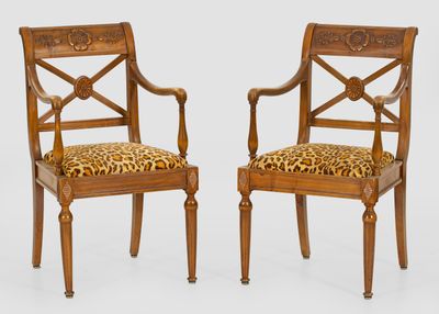 two wooden chairs with leopard print upholstered cushions
