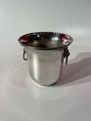 une tasse en argent posée sur une surface blanche