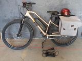 un vélo garé contre un mur, avec un sac posé dessus