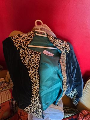 a pile of clothes on a bed with a red wall in the background