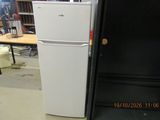 a white refrigerator sitting in a room with a black door