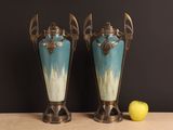 two vases sitting on a table with an apple next to them