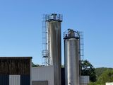 un grand bâtiment avec deux grands silos en arrière-plan
