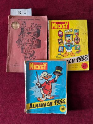 Trois livres sont posés les uns à côté des autres sur une surface rouge.