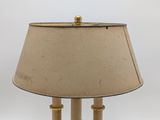 a lamp that is on a table with a beige shade