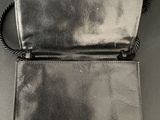 black leather clutch bag with gold buttons on the front