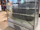 une vitrine vide dans un entrepôt rempli d'une multitude d'articles