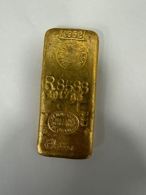 a gold bar sitting on top of a white surface