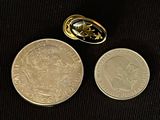two coins are next to a coin with a gold ring on top of it