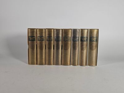 un ensemble de cinq livres en laiton vieilli sur fond blanc