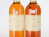 two bottles of wine sitting next to each other on a white surface