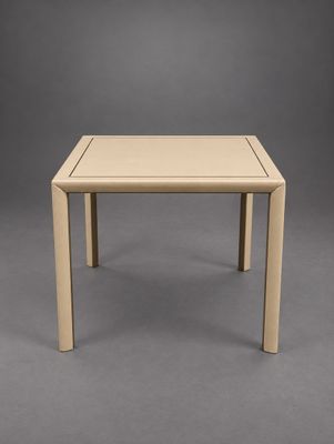 a small table with a square top on a grey background