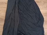 black and white skirt laying on the floor next to a pair of black pants