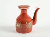 une petite théière rouge décorée d'un motif
