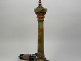une lampe à l'ancienne avec un pied en métal et un abat-jour en verre vert