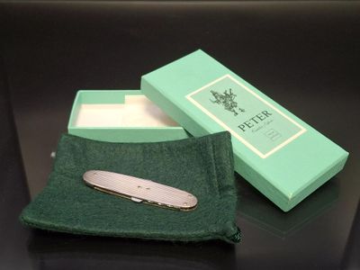 a small pocket knife in a green box on a table