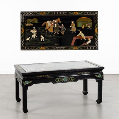 une table basse orientale avec un plateau en verre et un tableau accroché au mur