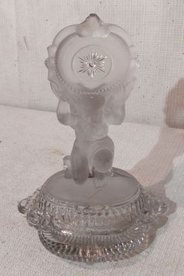 une figurine en verre surmontée d'une horloge
