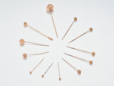 Un fort lot d'épingles à chapeau en métal doré se terminant …