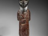 une statue en bois d'un homme avec un chapeau sur la tête