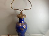 un vase bleu orné d'un motif doré, posé sur une table