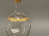 a clear glass vase with a gold rim on a table