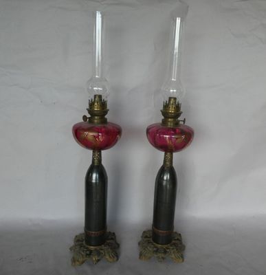 une paire de lampes en verre rose ornées de finitions dorées sur fond blanc