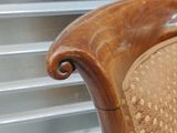 a close up of a wooden chair with a brown upholstered seat