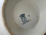 a close up of a white bowl with a crown on it