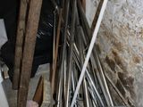 a pile of brooms and shovels in the corner of a room