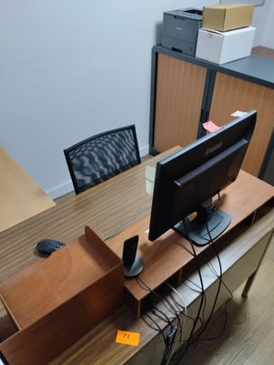 a desk with a computer monitor and a keyboard on it
