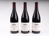 trois bouteilles de vin sont alignées sur une surface blanche