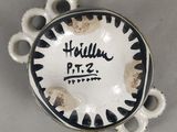 une photo d'une assiette blanche et noire sur laquelle figure un nom