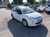 a small white car parked in a parking lot
