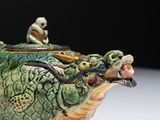 a small figurine sitting on top of a green turtle