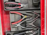 de nombreux outils dans une boîte à outils rouge posée par terre