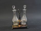 une paire de carafes en verre posées sur un socle en métal, sur fond noir