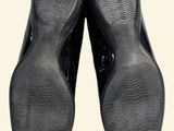 a pair of black shoes that are on a white surface